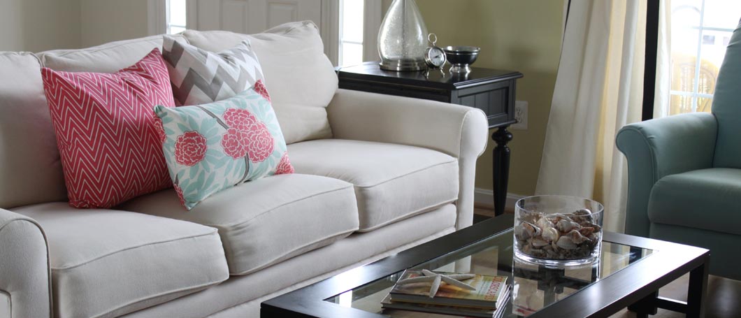 Tan couch with colorful accent pillow in a family room with good air quality